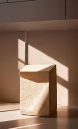 a square stone sits in the shadows in a room