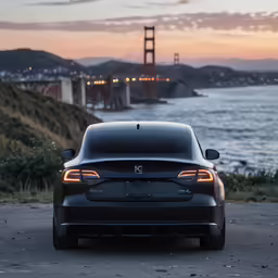 a gray sedan parked on the side of a road next to a body of water