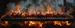 a bunch of meat is grilling on a grill