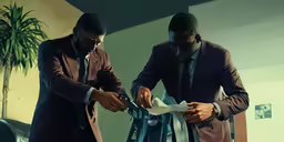two businessmen working on ties in their office