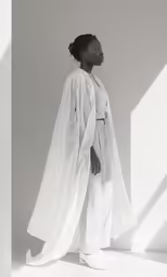 a woman standing with her cape pulled back