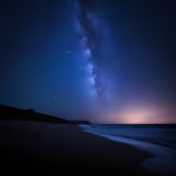 the night sky with stars and milky over the ocean