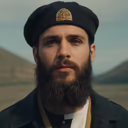 a close up of a man with a beard wearing a cap