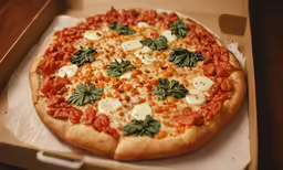 a fully cooked pizza with cheese, tomatoes, and green leaves