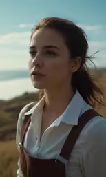 a woman in an apron and shirt looking at the camera