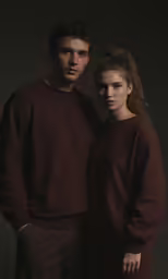 a man and a woman in sweatpants posing for the camera