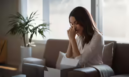 a woman in white is sitting and looking down