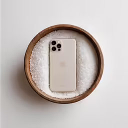 a small white phone sitting in a wooden box