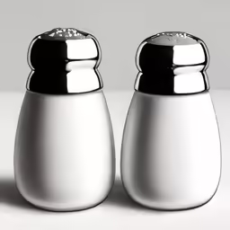 two salt and pepper shakers sitting on top of a table