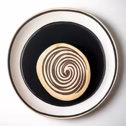a wooden object sits on top of a black and white plate