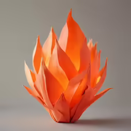 a orange paper flower sits upright on a gray surface