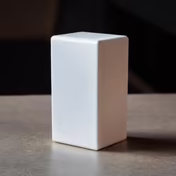 a small white cube sits atop a table