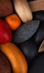 some colorful rocks and oranges on top of a black surface