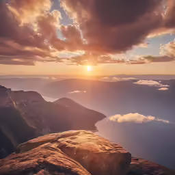 the sun setting above the mountains and clouds
