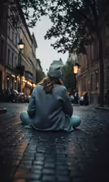 a person sitting on the ground, staring up to the sky
