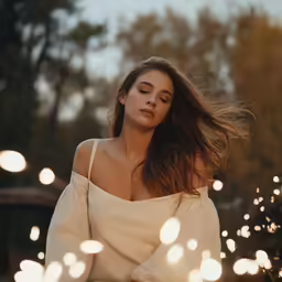 a woman is posing with her hair blowing in the wind