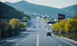 the road in front of the mountains is lined with cars