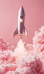 a plane flying in the sky over pink smoke