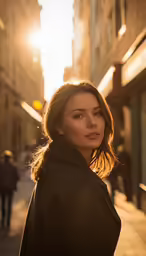 a woman standing on the side walk in the sunset
