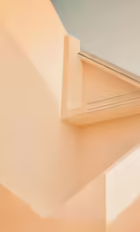 a corner of a beige wall with a building