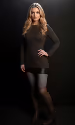 a beautiful blond wearing tight stockings and black shirt posing for a photo