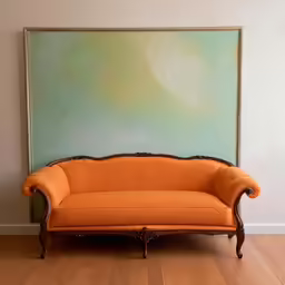 a very beautiful yellow couch sitting in front of a painting