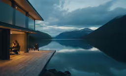 a couple sitting on a porch by a lake