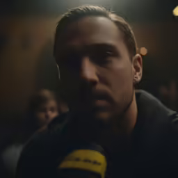 a man is staring into the camera with his head in a microphone