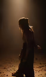 a girl walks in the dark with her hair blowing