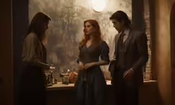 a man in suit talking to other people near table