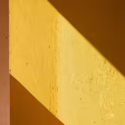 the light shining through the shadow of a wall