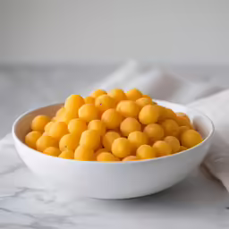 a bowl filled with yellow balls of some sort