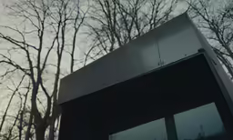 a black window with some trees in the background
