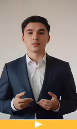 an image of a young man in suit standing with his hands folded