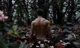 a guy with no shirt on in the woods