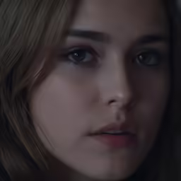 a woman with blonde hair and large eyes staring at the camera