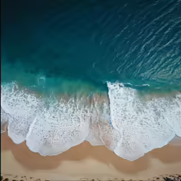 the aerial view of a sandy beach in the water