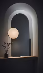an illuminated lamp on a table with a flower vase and pot