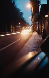 a city street in the snow with a very long line of parked cars