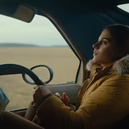 the young woman is driving the car in the rain