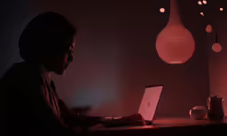 person sitting at a table with their laptop