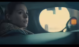 a woman sitting in a car looking out the window