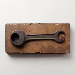 an old spanner hanging from a wooden stand