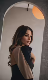 a beautiful woman with long hair in a black and beige dress