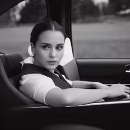 the woman in black vest is sitting in a car