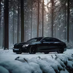 a black mercedes c6 driving on snow covered ground