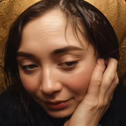 a close up shot of a woman touching her head