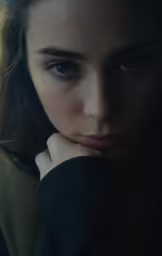 a girl with dark hair is looking at the camera
