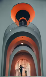 a tall hallway with stairs and a round stair case
