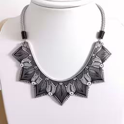 a necklace with an intricate design on it,a necklace with beads and leaves on the front